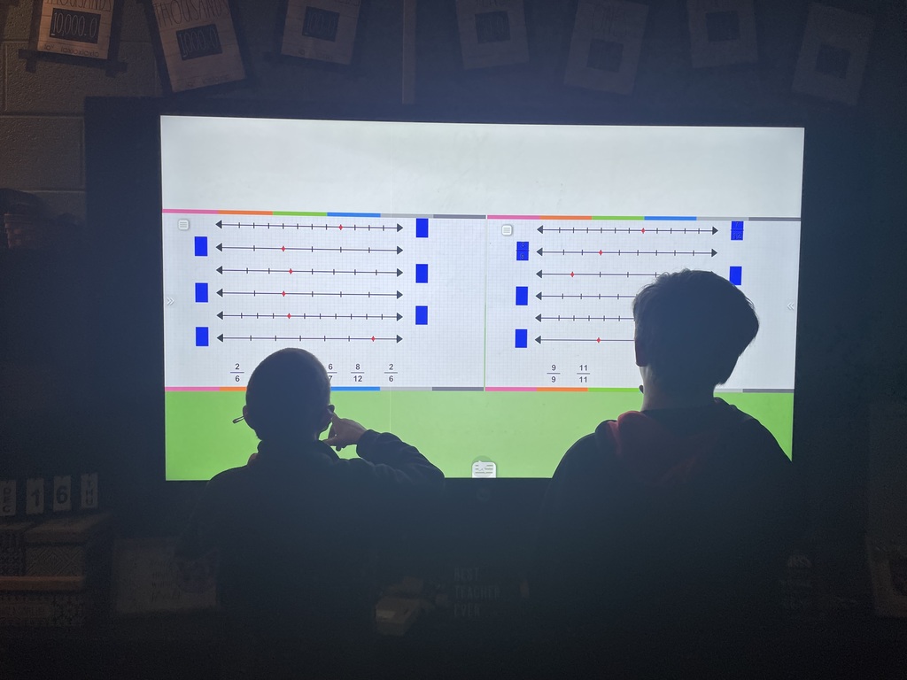 Mrs. McKenzie's  students work on interactive panels  to reinforce fraction lines.
