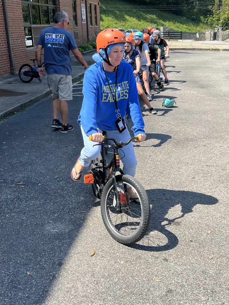 Mrs. McKenzie shows the kids how to ride a bike safely.